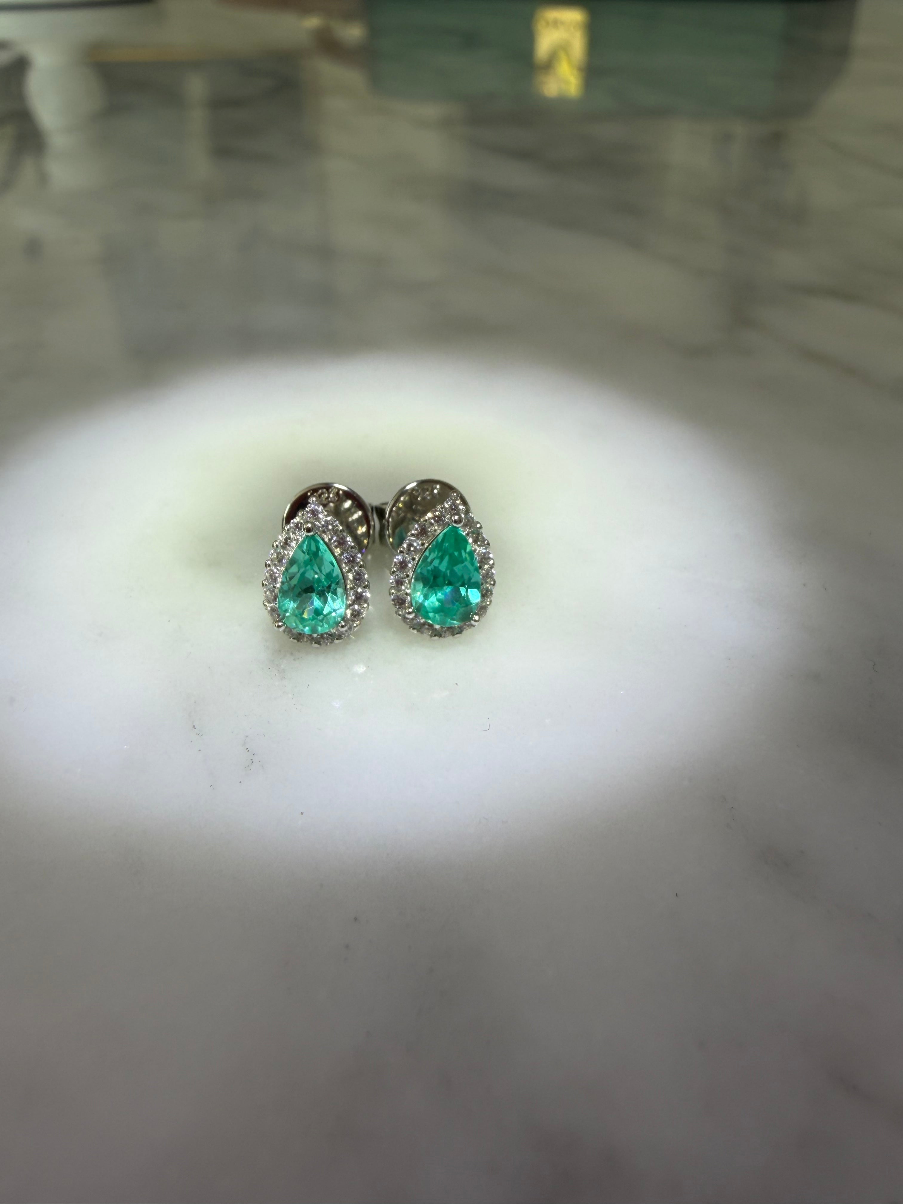 The Paraiba Halo — pear-cut Paraiba-blue stone with white halo, close detail on marble