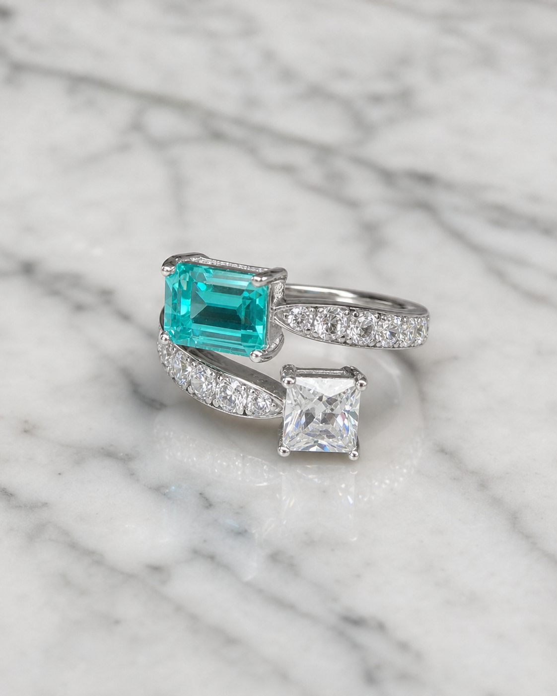 Paraiba Toi et Moi two-stone ring, angled view on marble showing the bypass band