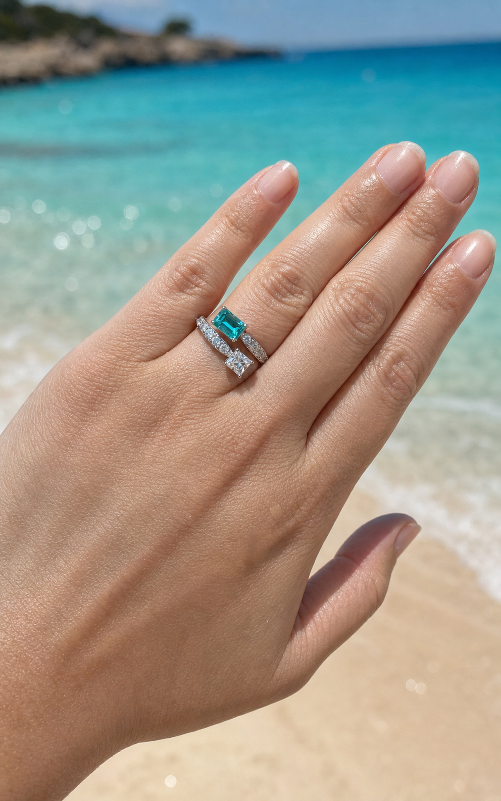 Paraiba Toi et Moi ring worn on the hand by a turquoise Majorca beach