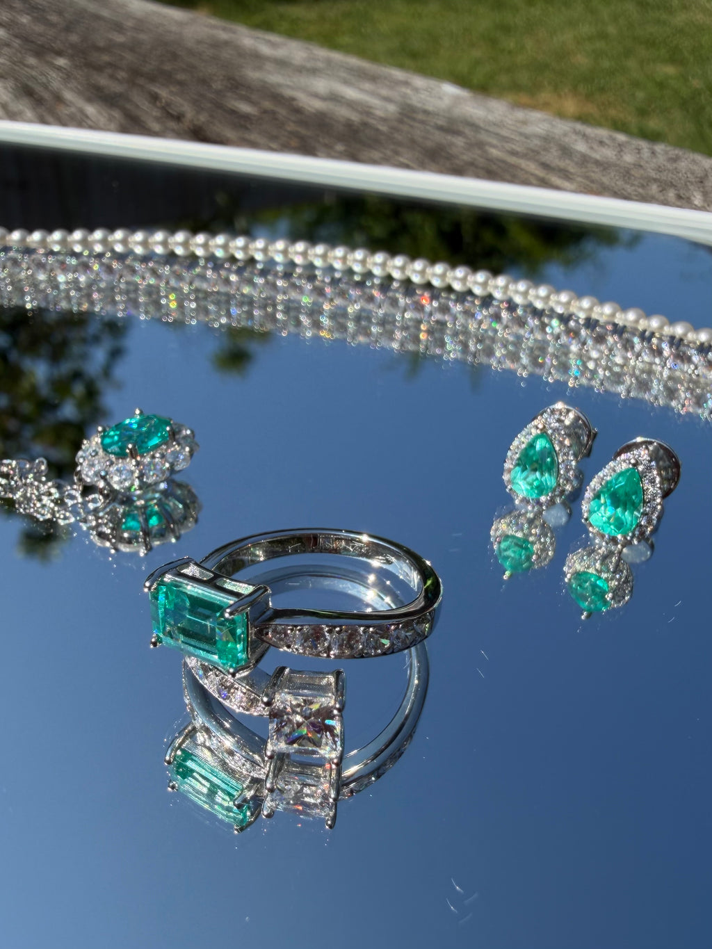 The Paraiba Halo earrings styled with the matching Paraiba-blue ring, bracelet, and necklace