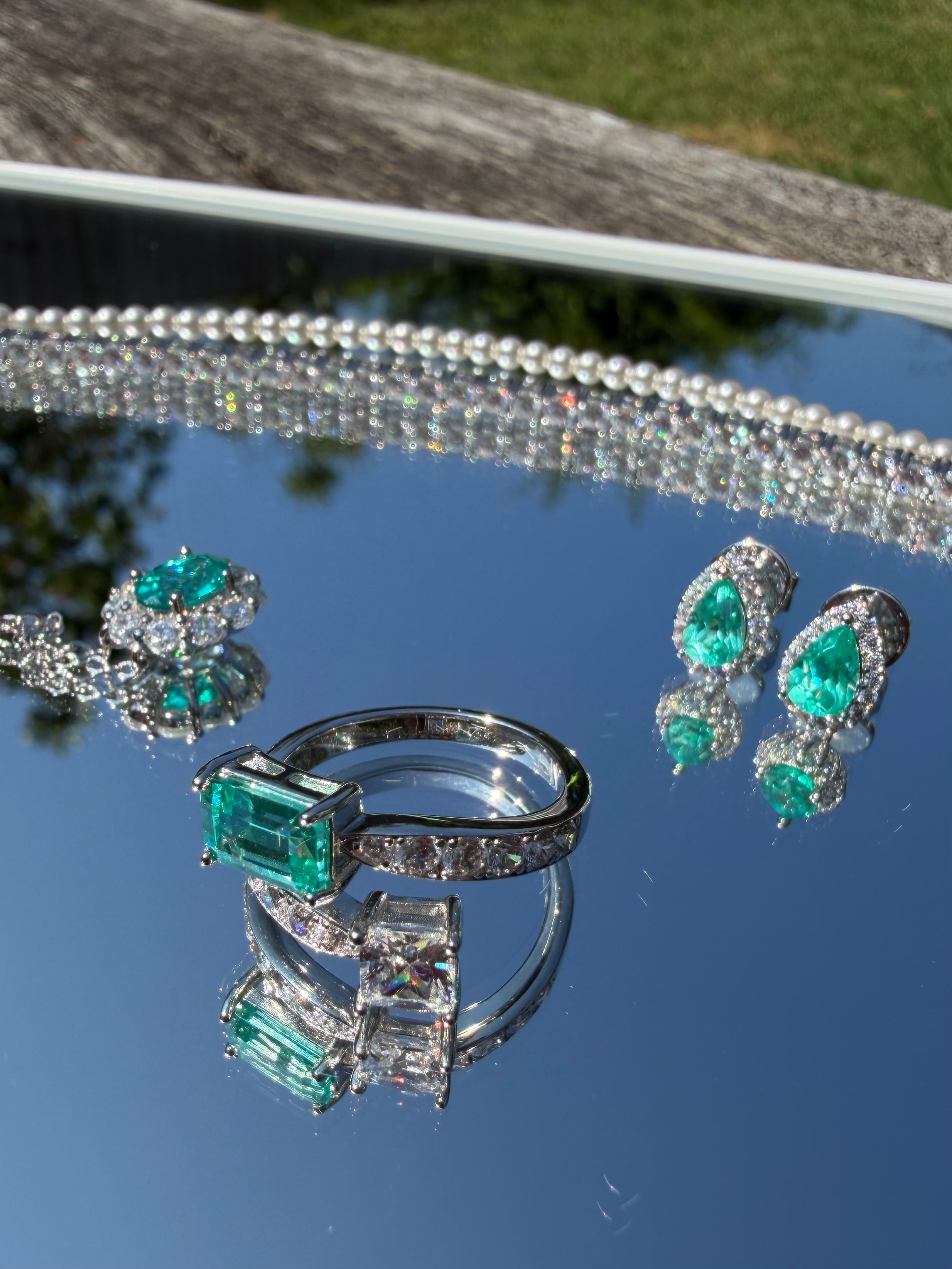 The Paraiba Halo earrings styled with the matching Paraiba-blue ring, bracelet, and necklace