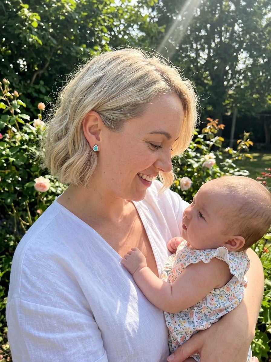 The Paraiba Halo earring worn outdoors by a mother holding her baby