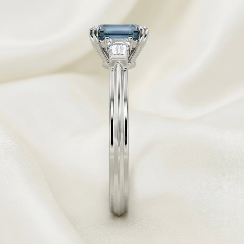 trilogy diamond with blue diamond, emerald cut, platinum band 