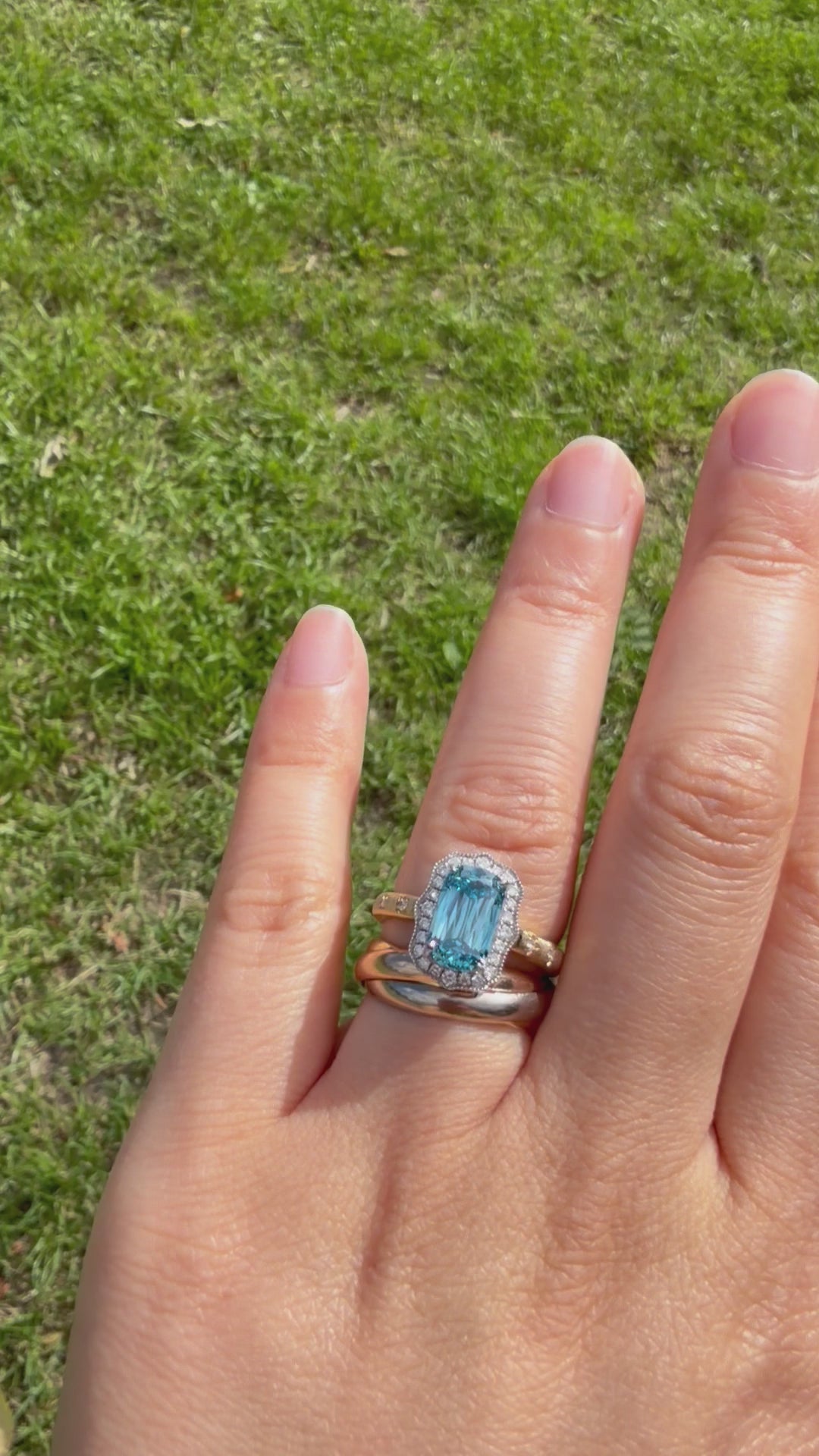 The Tidal Vow rotating to show the lab-grown blue diamond, scalloped white diamond halo, and hand-brushed 18K gold band