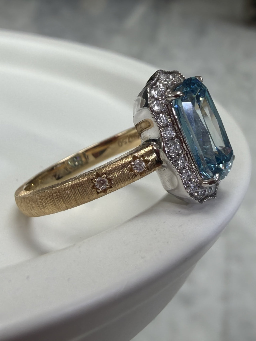 Side view of the hand-brushed 18K gold band with star-set diamond shoulders and Au750 hallmark